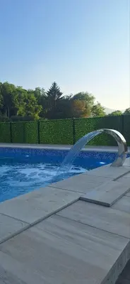 a swimming pool with a fountain in the middle at Zem Zem kuća za odmor in Otoka