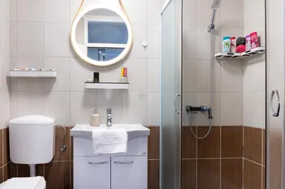 a bathroom with a toilet and a sink and a mirror at Apartman Haba Vlašić in Vlasic