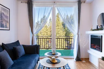 a living room with a couch and a large window at Apartman Haba Vlašić in Vlasic