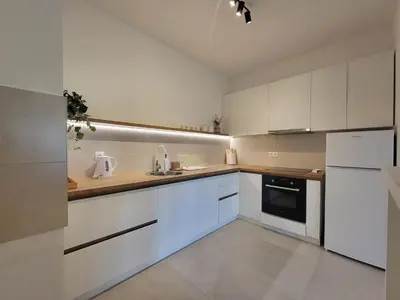 a kitchen with white cabinets and white appliances at Green view apartment in Banja Luka