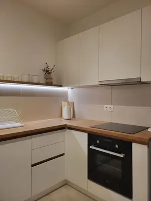 a kitchen with white cabinets and a black oven at Green view apartment in Banja Luka