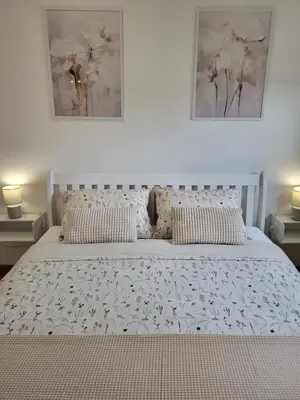 a bedroom with a white bed with flowers on it at Green view apartment in Banja Luka