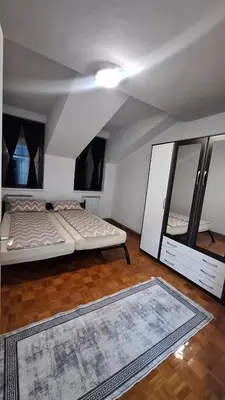 a living room with two beds and a rug at Atika in Cazin