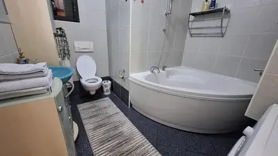 a bathroom with a white tub and a toilet at Atika in Cazin