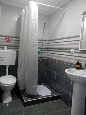 a bathroom with a shower with a toilet and a sink at EM Apartments in Tuzla