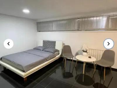 a bedroom with a bed and a table and two clocks at EM Apartments in Tuzla