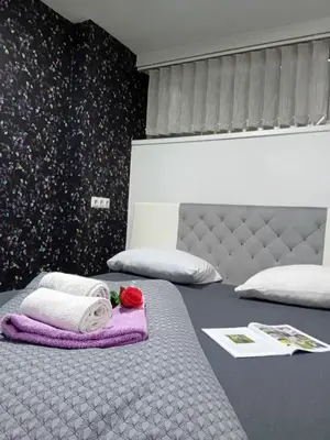 a bed with a towel and a rose on it at EM Apartments in Tuzla