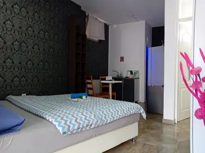 a bedroom with a bed and a table in it at EM Apartments in Tuzla