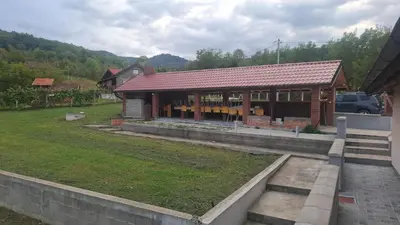 a house with a red roof in a yard at Ivanović Vikendica