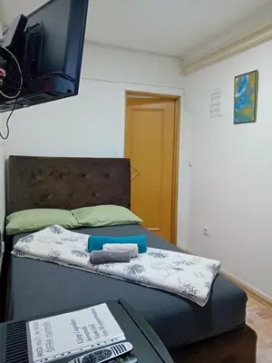 a bedroom with a bed with a tv on the wall at EM Apartments Korzo in Tuzla