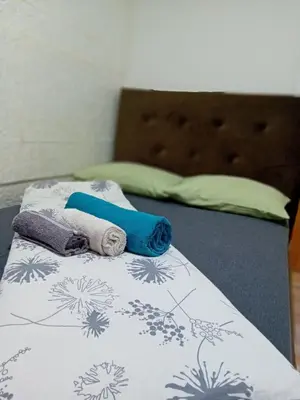 a bed with two towels on top of it at EM Apartments Korzo in Tuzla