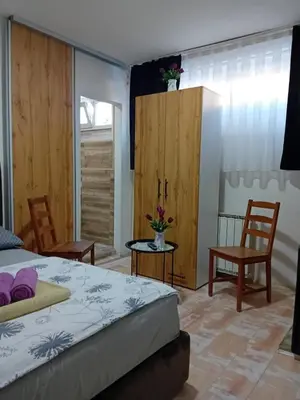 a bedroom with a bed and two chairs at EM Apartments Korzo in Tuzla