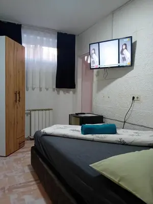 a bedroom with a bed with a flat screen tv on the wall at EM Apartments Korzo in Tuzla