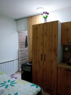 a bedroom with a large wooden cabinet and a bed at EM Apartments Korzo in Tuzla