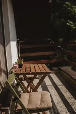 a wooden picnic table on a balcony with a plant at Forrest House in Doboj