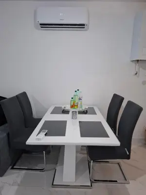 a white table with black chairs in a room at Apartman Ditka in Bihać