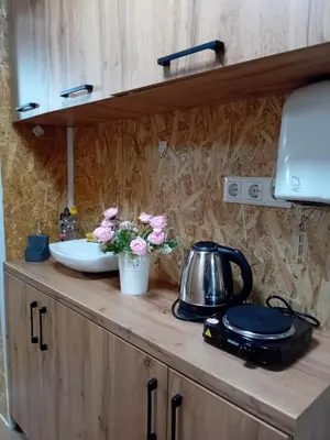a kitchen counter with a tea kettle and flowers on it at Gyps Vikendica with Swimming Pool and Sauna in Tuzla