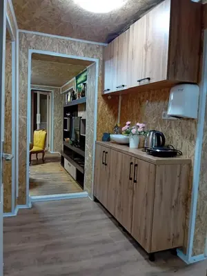 a kitchen with wooden cabinets and a counter at Gyps Vikendica with Swimming Pool and Sauna in Tuzla