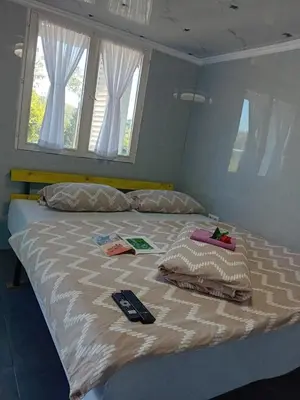 a bed with two remote controls on top of it at Gyps Vikendica with Swimming Pool and Sauna in Tuzla