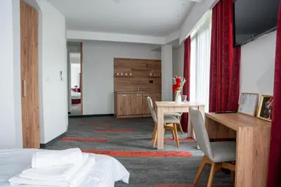 a room with a bed and a table and chairs at Motel Brist in Zenica