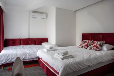 a bedroom with two beds and a red couch at Motel Brist in Zenica