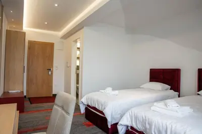 a hotel room with two beds and a chair at Motel Brist in Zenica