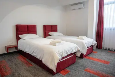 two beds in a room with red frames at Motel Brist in Zenica