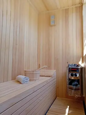 a sauna with a tub on a wooden wall at Gyps Vikendica with Swimming Pool and Sauna 2 in Tuzla