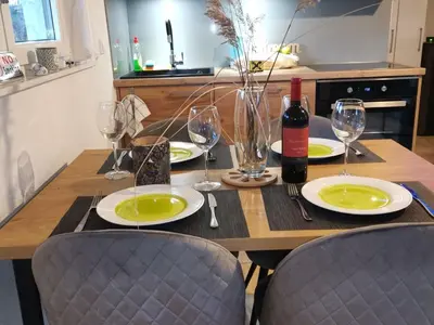 a wooden table with plates and wine glasses on it at Kuća za odmor Villa Lana Bihać in Bihać