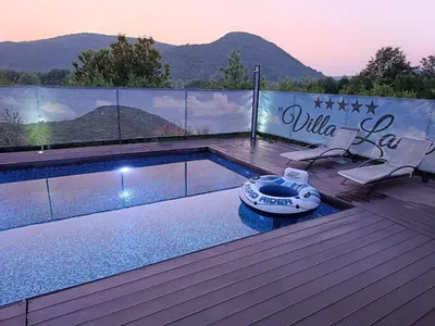 a swimming pool on a deck with a view of mountains at Kuća za odmor Villa Lana Bihać in Bihać