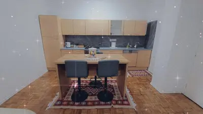 a kitchen with a table and two blue chairs at Apartmani E&A Jasmina Okanović in Gradačac