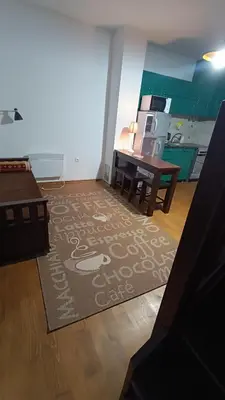 a living room with a kitchen with a table and a rug at Mountain Home
