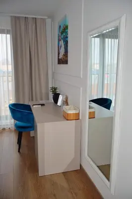 a white desk with a blue chair and a mirror at Mas Motel in Bosanska Gradiška