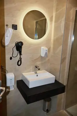 a bathroom with a sink and a mirror and a camera at Mas Motel in Bosanska Gradiška