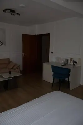 a living room with a table and a blue chair at Mas Motel in Bosanska Gradiška