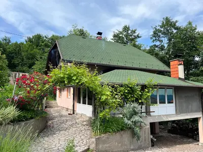 a house with a green roof and some flowers at Relax House