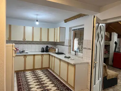 a kitchen with wooden cabinets and a white counter top at Relax House