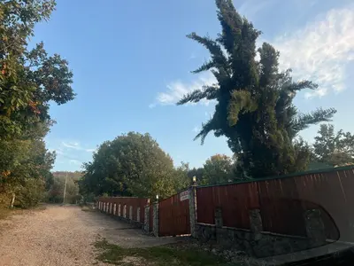 a fence with a tree on the side of a road at Relax House