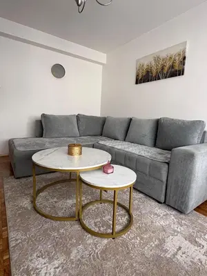 a living room with a gray couch and two tables at A&N Apartments in Banja Luka