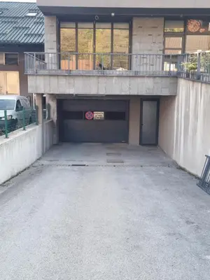 a parking lot with a garage with a balcony on top at Apartman Sunce in Zenica