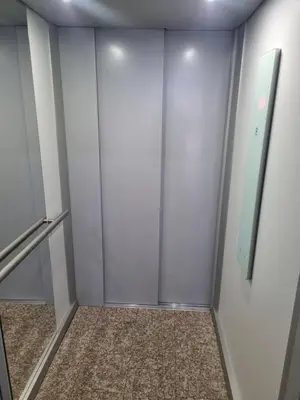 a walk in closet in a building with a glass door at Apartman Sunce in Zenica