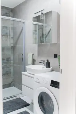 a bathroom with a washing machine and a sink at Liberty Studio Tuzla in Tuzla