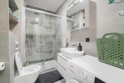 a bathroom with a toilet and a sink and a shower at Liberty Studio Tuzla in Tuzla