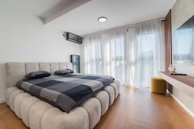 a large bed in a room with a large window at Liberty Studio Tuzla in Tuzla