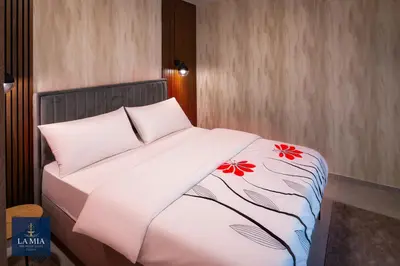 a bed with white sheets and red flowers on it at La Mia Premium Suite in Tuzla