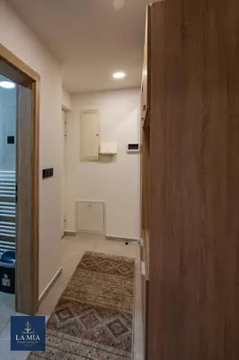 a room with a hallway with a door and a rug at La Mia Premium Suite in Tuzla
