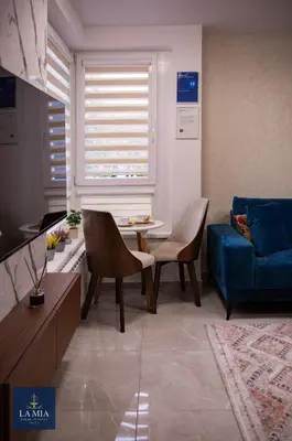 a living room with a blue couch and a table at La Mia Premium Suite in Tuzla