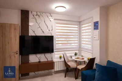 a living room with a television and a table at La Mia Premium Suite in Tuzla