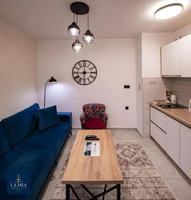 a living room with a blue couch and a table at La Mia Premium Suite in Tuzla