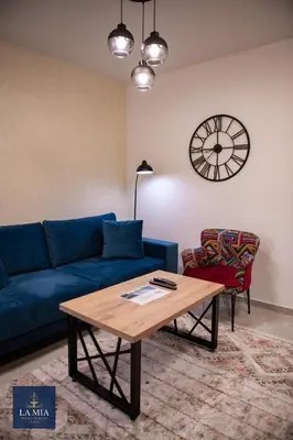 a living room with a blue couch and a table at La Mia Premium Suite in Tuzla